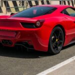 A Ferrari 458 Italia hátsó nézete, élénk piros színben, versenypályán.