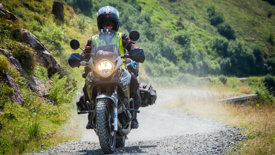Motorkerékpáros terepen, porfelhőt kavarva halad a végsebesség-teszt során.