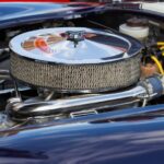 Egy V8-as motor részlete, fényes légszűrővel és csövekkel.