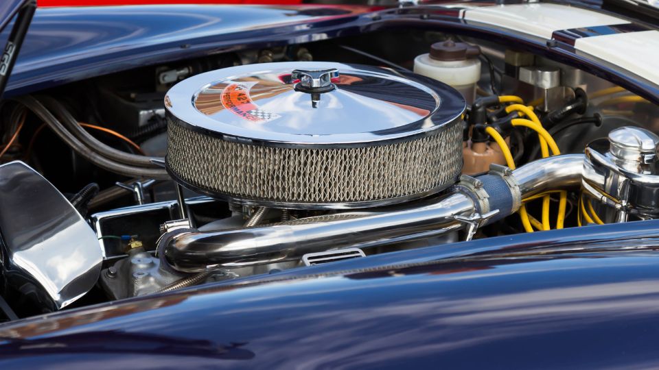 Egy V8-as motor részlete, fényes légszűrővel és csövekkel.