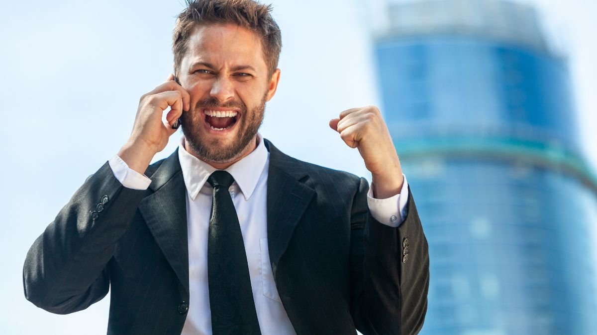 Sikeres férfi telefonál, izgalommal ünnepli győzelmét.